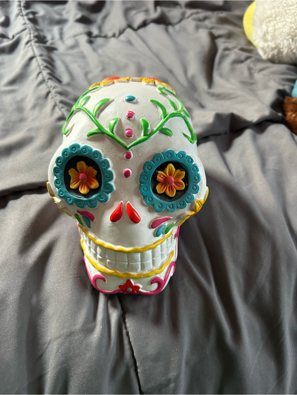 Day of the dead sugar skull with floral and designs in green, blue, pink